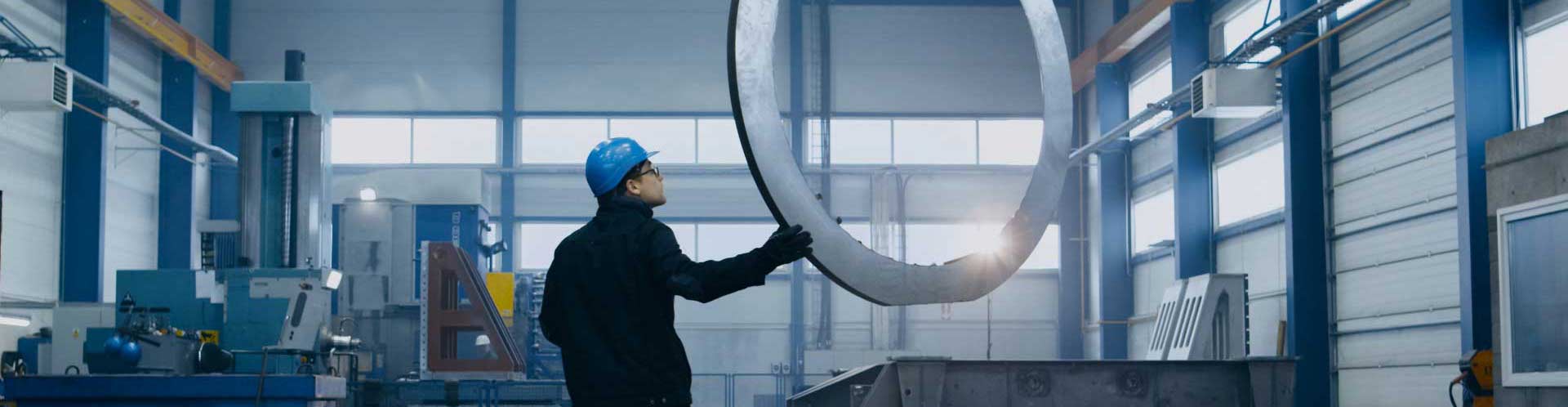 man checking machinery in steel factory
